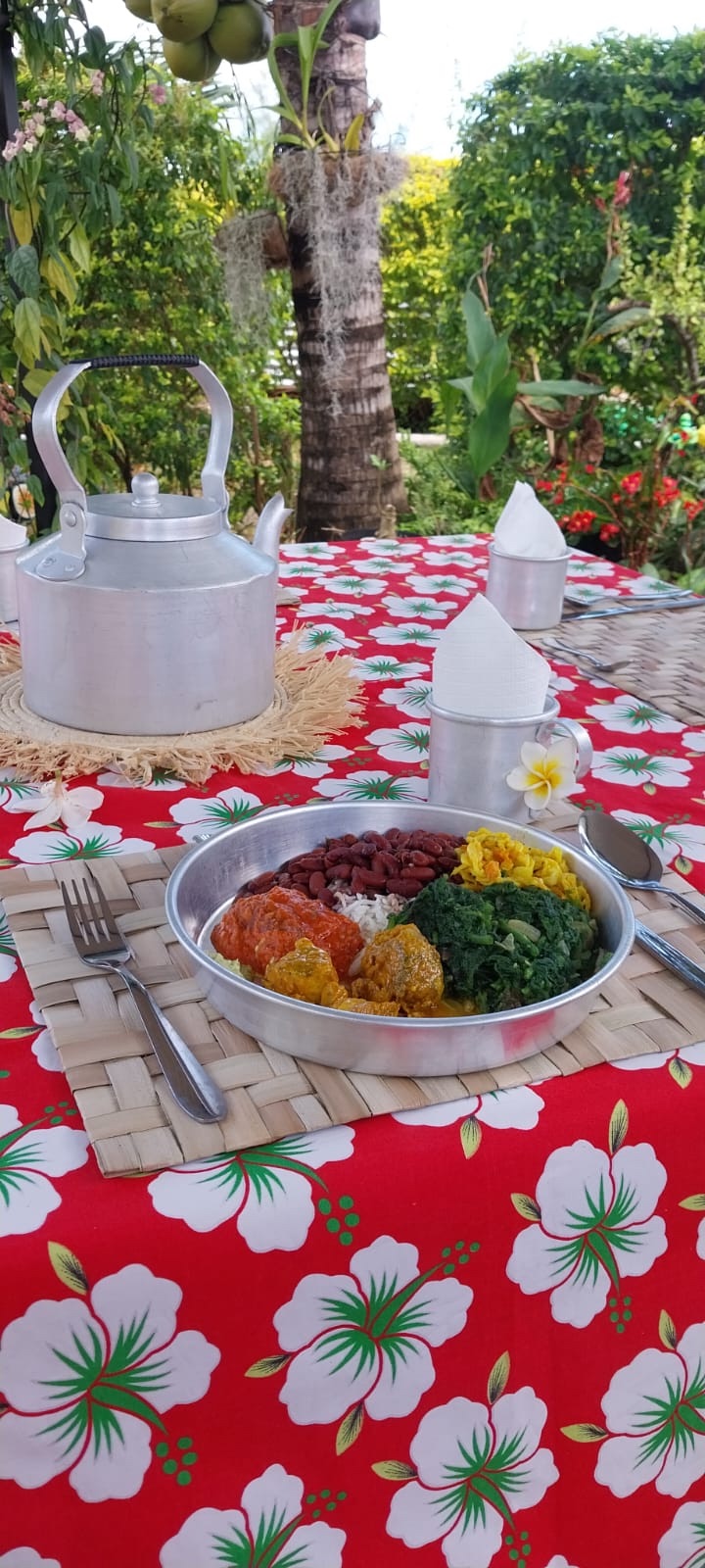 Un thali mauricien posé dans la verdure : riz, brèdes, dhal et achards